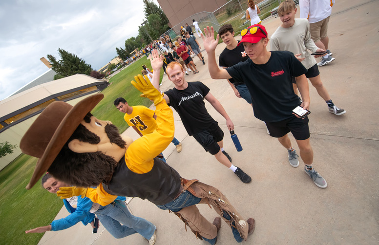 student high five pistol pete at an event 