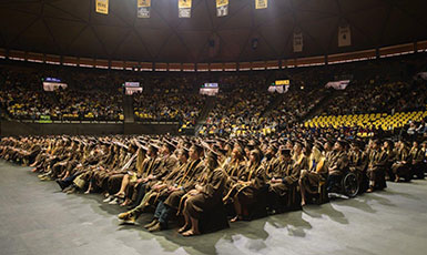 students in caps and gowns seated 