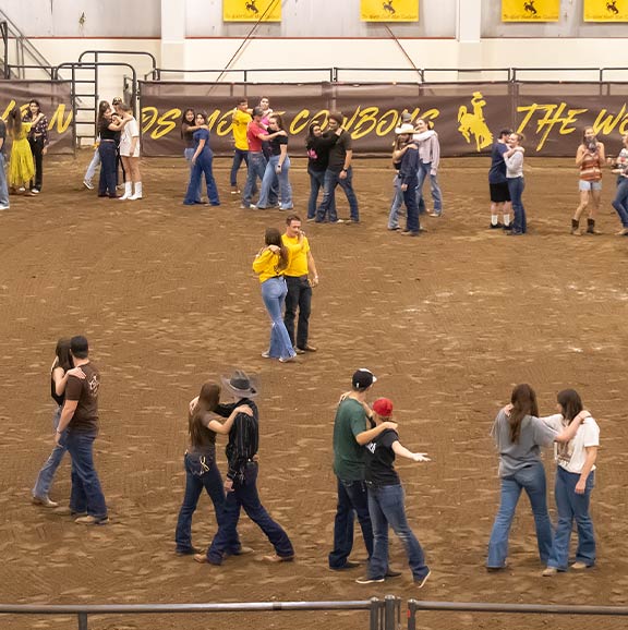 people dancing on a dirt arena