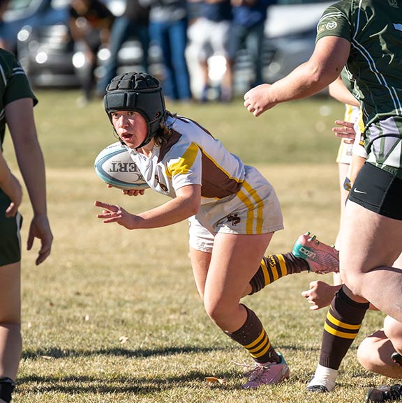 woman playing rugby, running with the ball