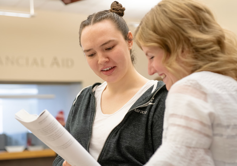 A UW student and faculty member meet together and discuss course options.