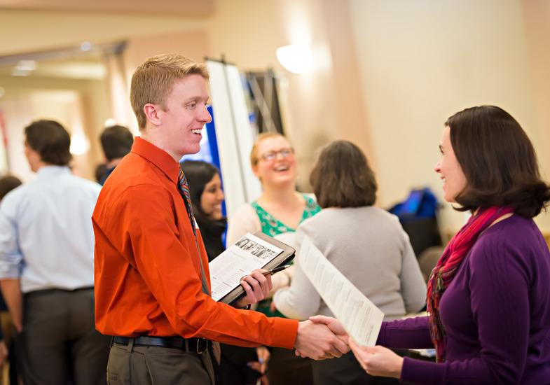 A UW student shakes the hand of a potential employer at a UW Career Services job search event.