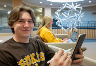 student works on thier phone with a stylist