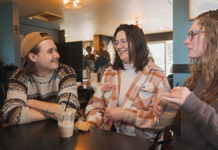group of students laughing over coffee