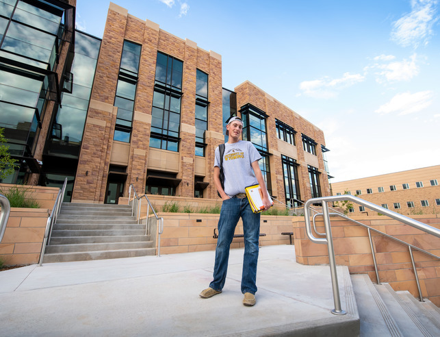 student stand in front of the engineering building on campus