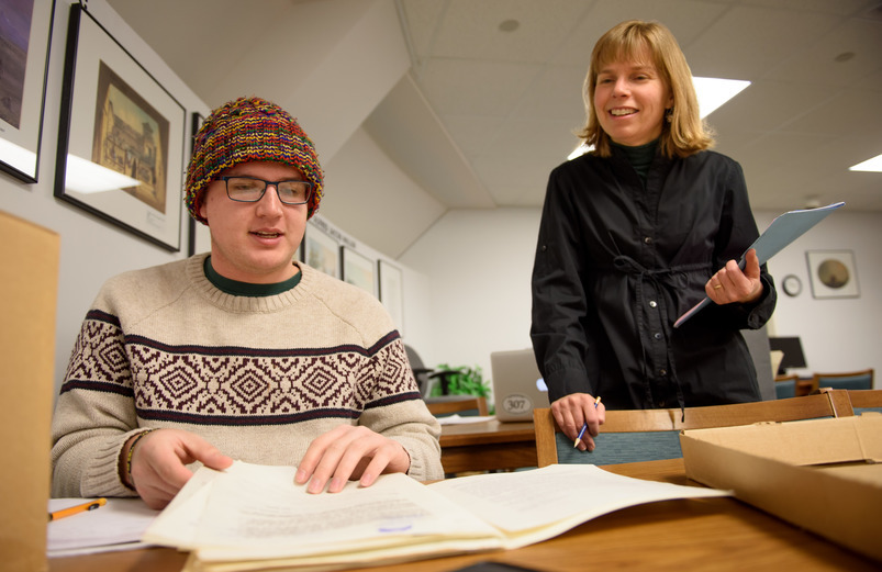 Two people work together in the archives at the American Heritage Center