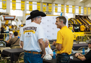 The dean and an alumni celebrate homecoming