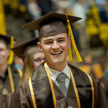 A student smiles during commencement