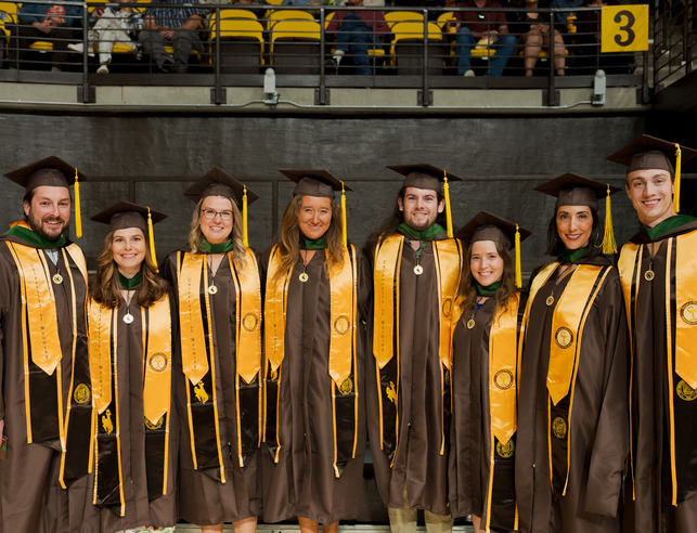 A group of student smile for a photo during commencement