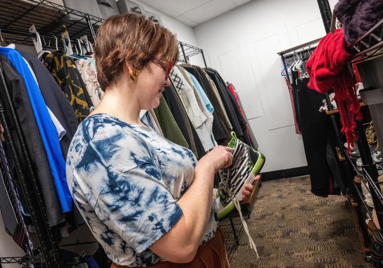 Woman looking at a shoe in the campus closet