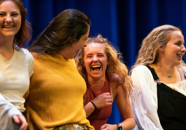 A group of students from a UW sorority share a laugh on stage during a University of Wyoming fraternity and sorority life event