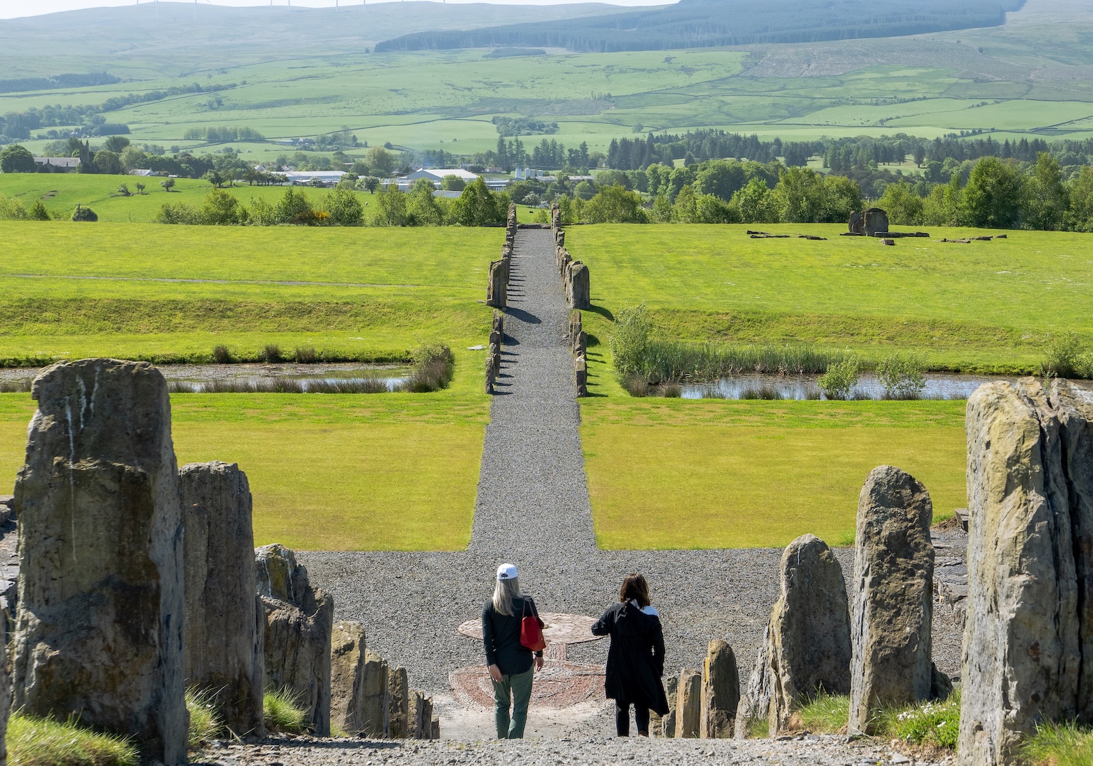 Two Wyoming community members walking through pillars at Crawick Multiverse