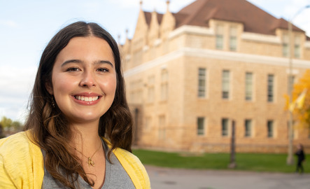 a student smiles outside on campus