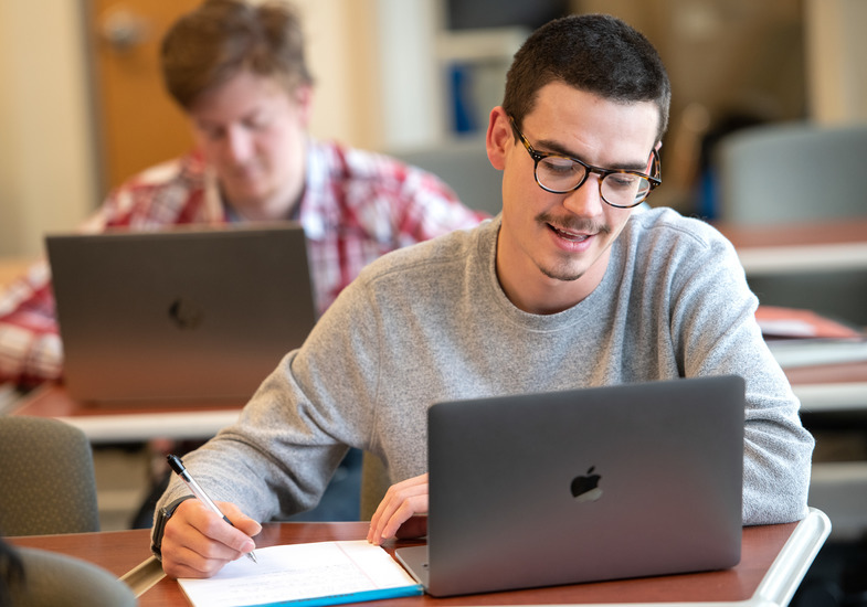 a student sits at their laptop