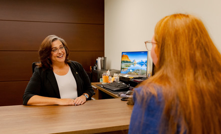 staff talks with a student across a desk