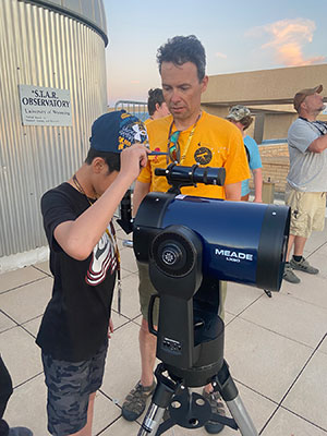 man helping child with telescope