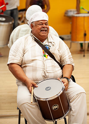 man sitting with a drum between his knees