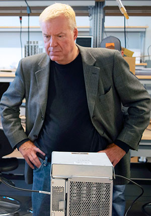 man standing and looking at a boxy device