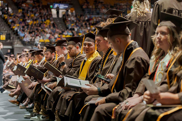 people in caps and gowns seated in a row