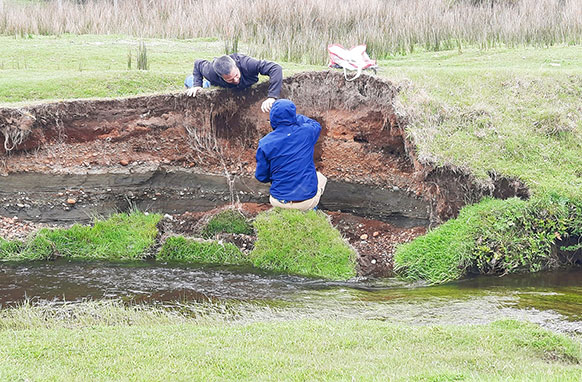 two people working on a creek bank