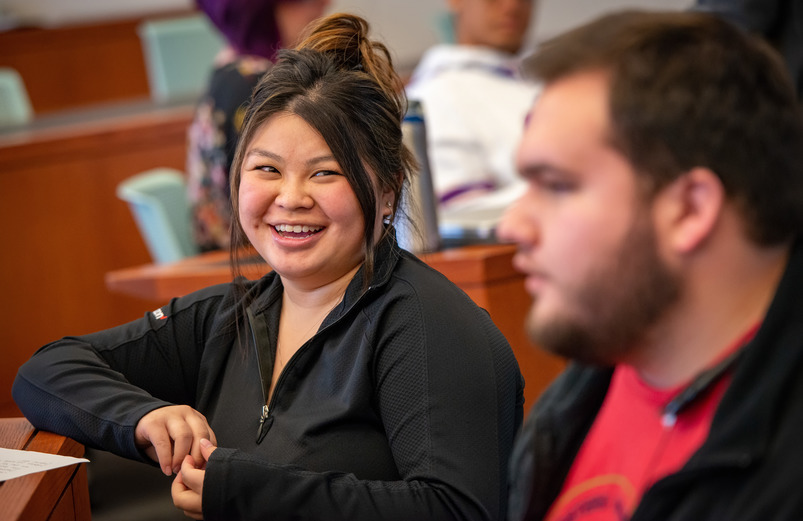 A UW student broadly smiles during a class discussion at the University of Wyoming