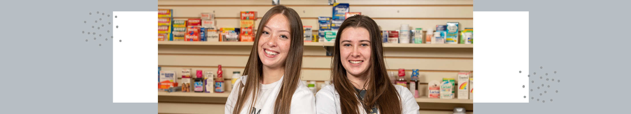 two pharmacy students in white coats
