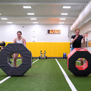 Two students participate in a fitness class in Half Acre Gym