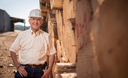 A REDD partner and Wyoming business leader stands in a lumber yard.