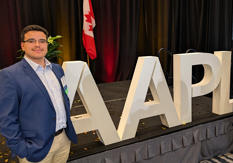A student standing in front of an AAPL sign