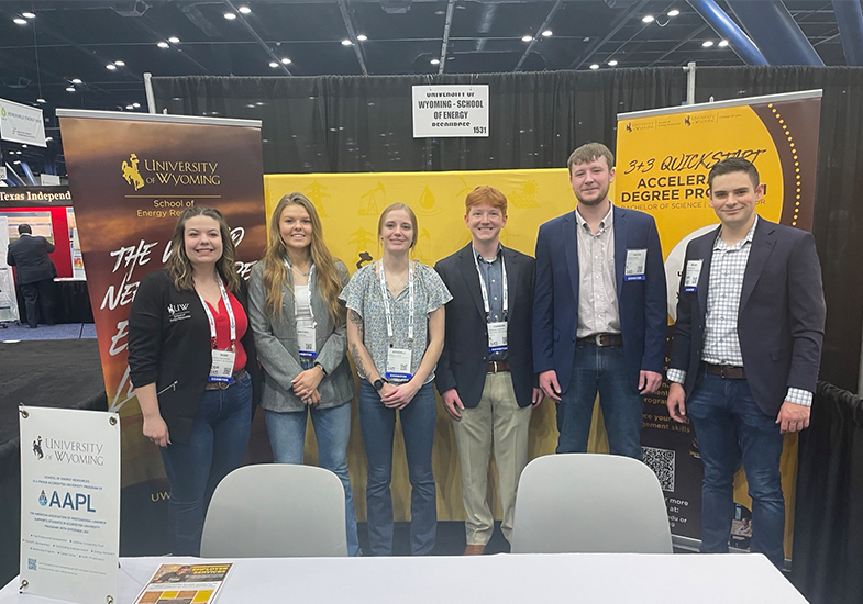 students standing in a booth on a trade expo floor in Houston