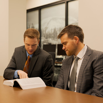 Two law students study a book together at a table