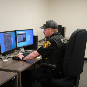 A police officer works on a computer