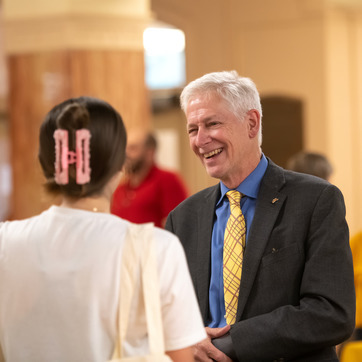 President Seidel smiling while talking with a student