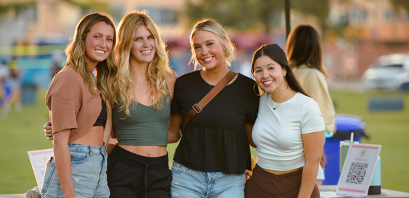 Students stand in front of tent at event