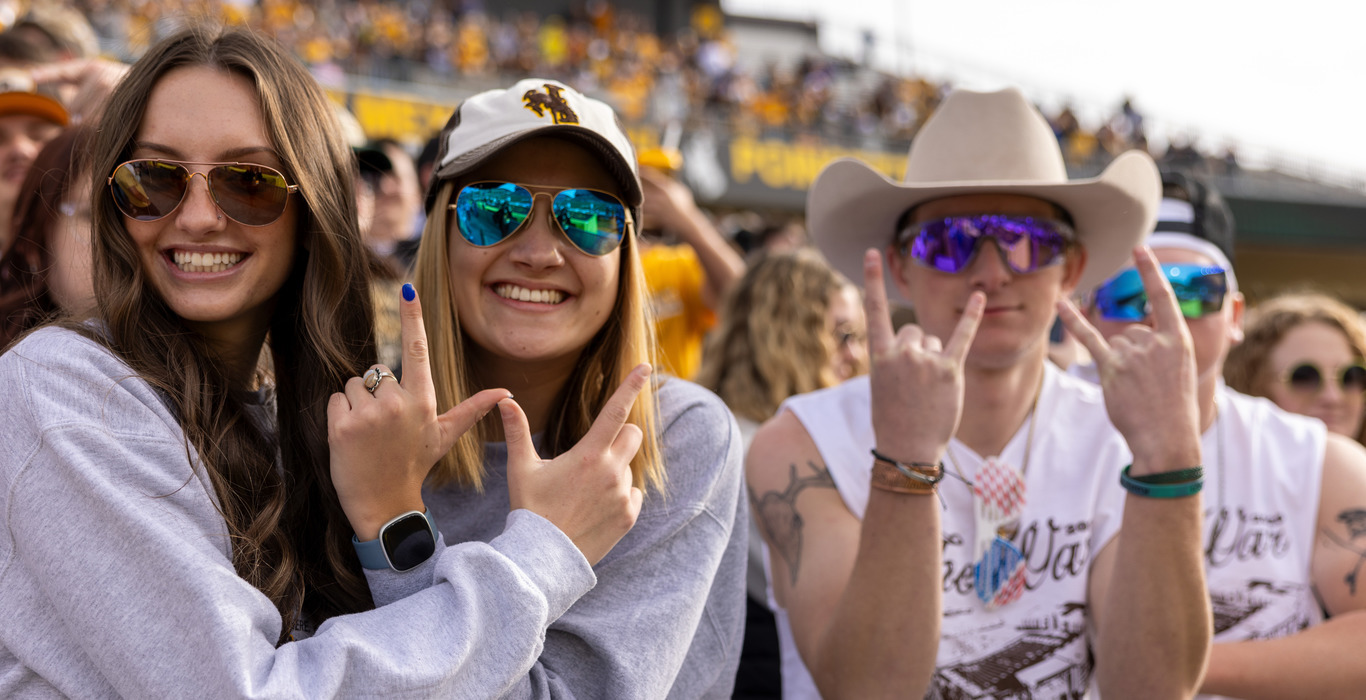 A student sits proudly in their mortar board listening to the UW commencement speaker.