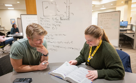 A UW student and tutor work together on coursework to help ensure student success.