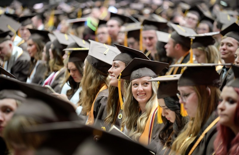 UW students sit in their caps and gowns as they wait for a University of Wyoming Commencement Ceremony to begin.