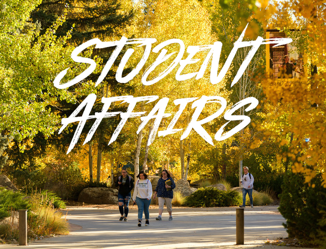 Trees in the fall with students walking, with Student Affairs written on top