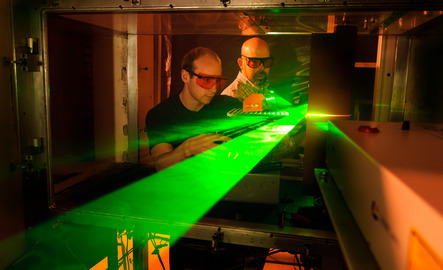 Two mechanical engineers work with a laser