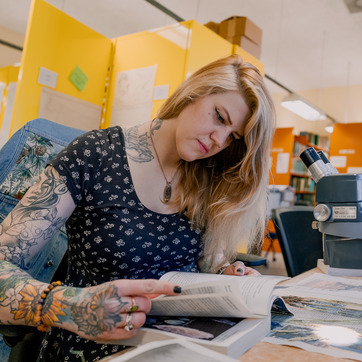 A student reviews research in a lab with a microscope