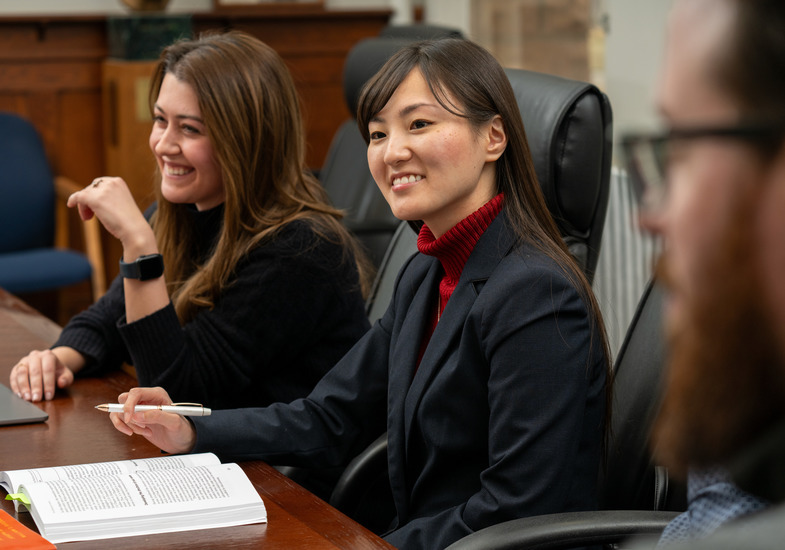 UW graduate students sit around a conference table having a discussion for one of their courses.