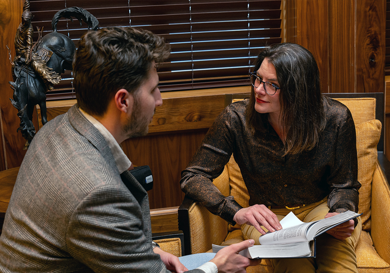 female professor and male student looking at a book