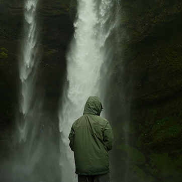 A UW study abroad student poses in front of a waterfall in Iceland