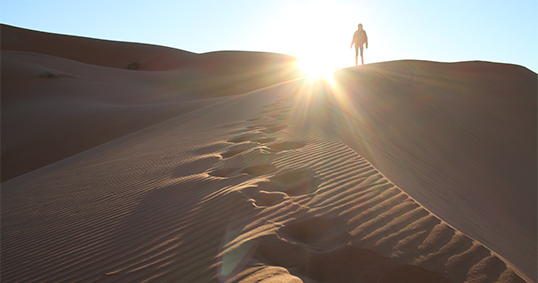 UW study abroad students walks through sand dunes in the Saharas