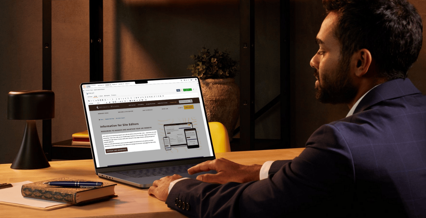 A person sits at a computer with a UW Modern Campus CMS interface pulled up on the screen.