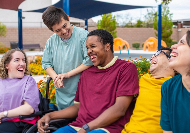 A group of students laughing together on a college campus