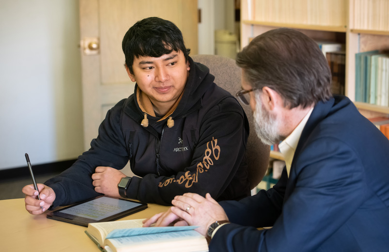 student at a table withe professor