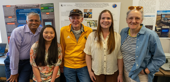 A group of students, professors and the president of UW smile for a picture
